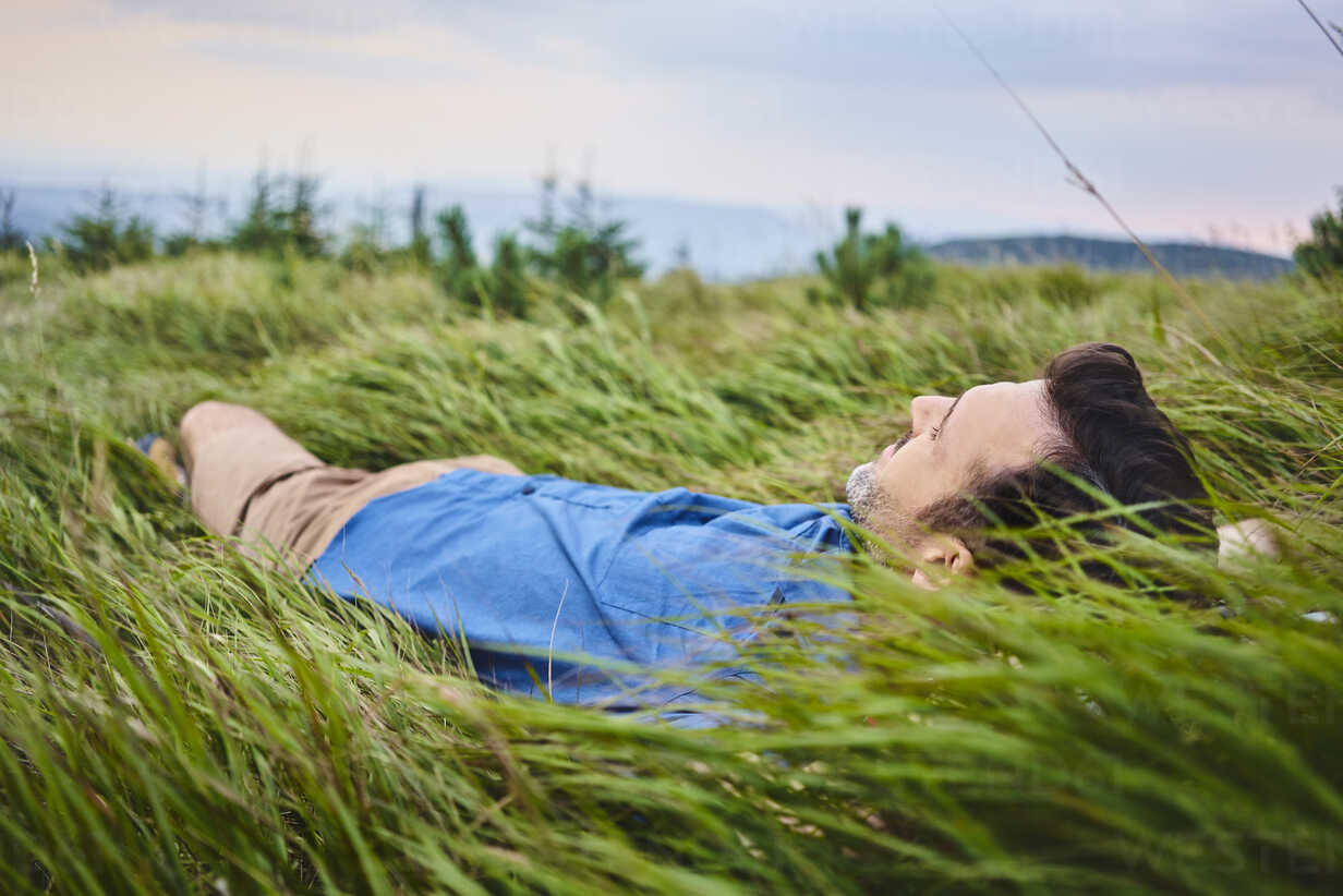 relaxed-man-lying-in-grass-BSZF00748